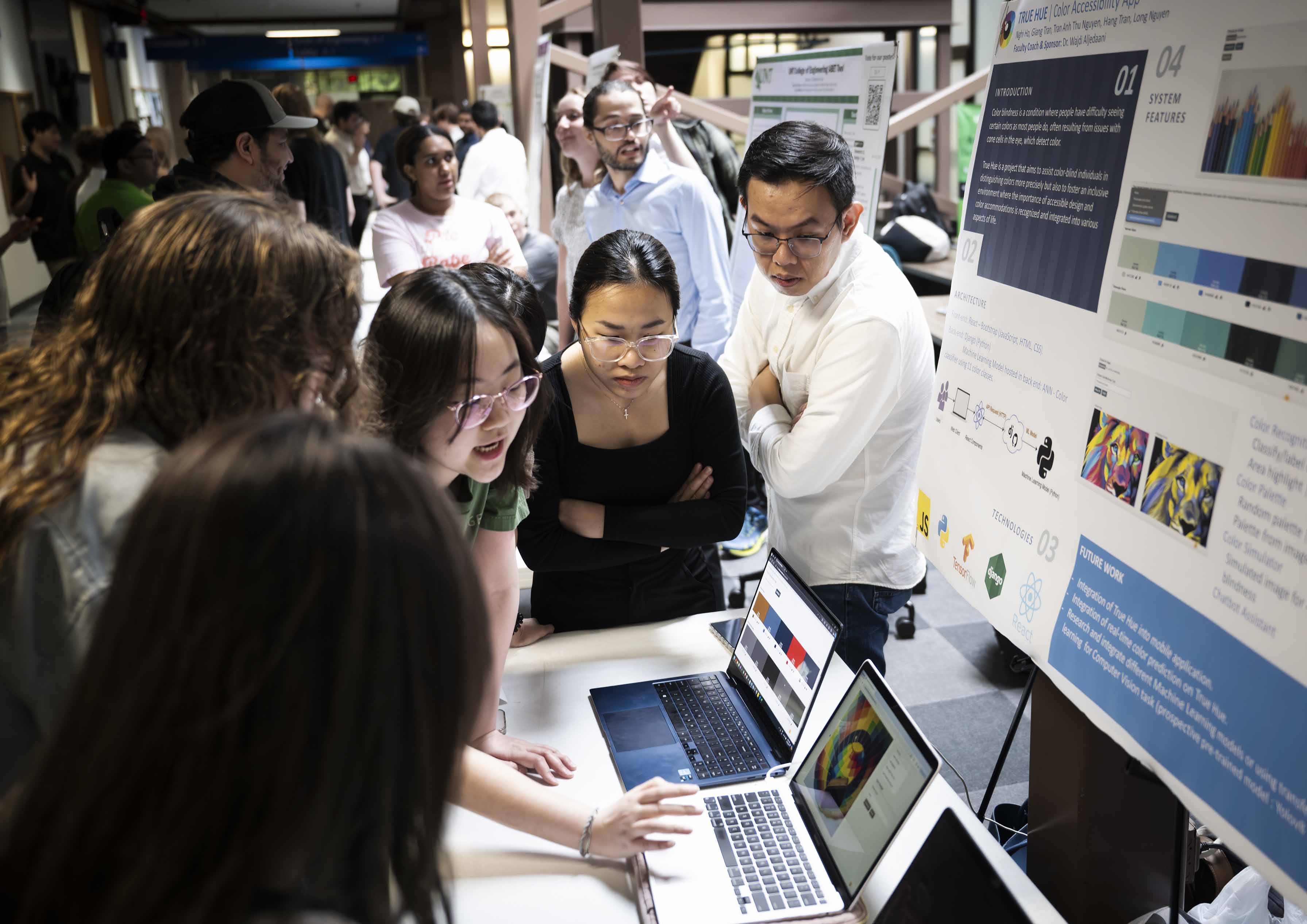 Photo of UNT engineering students gathered around a research poster at senior design day