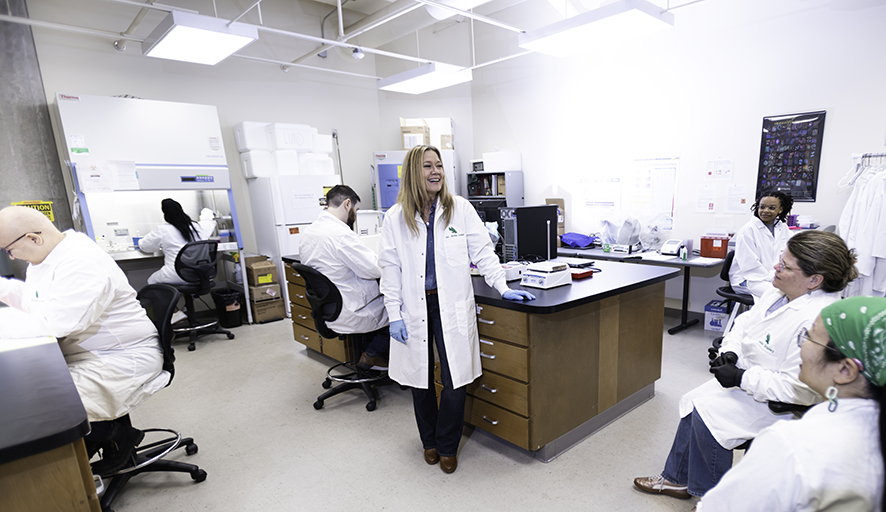 UNT associate professor Amie Lund stands in her lab as her students work nearby.