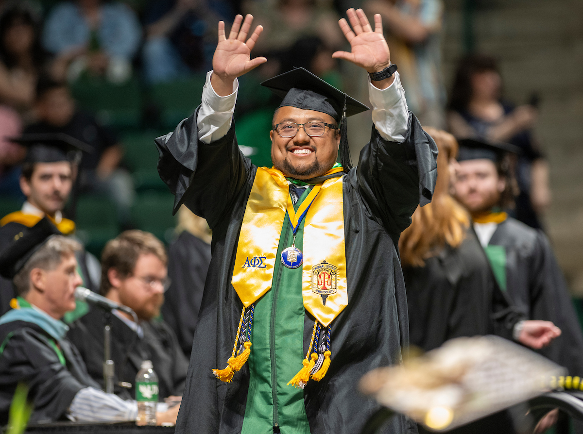 Masters student walking at a commencement ceremony