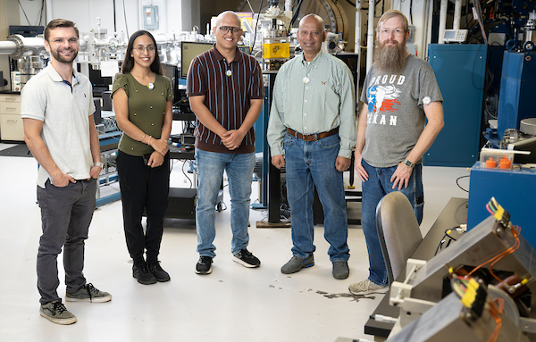 5 individuals standing in a lab looking at camera