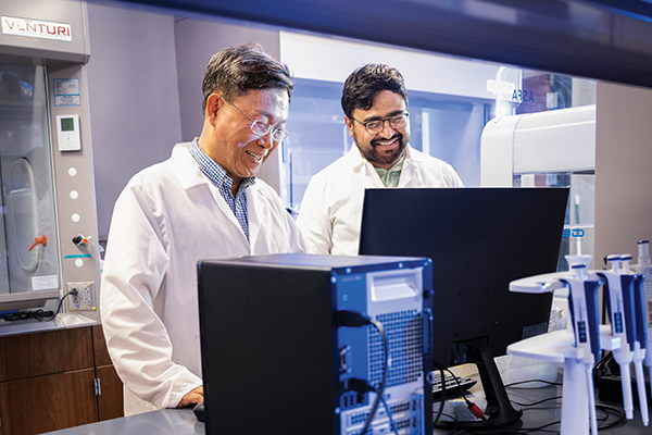 Associate professor Moo-Yeal Lee talks with student Sunil Shrestha in his Bioprinting Lab at UNT.