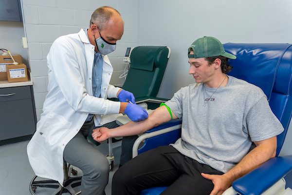 Jakob Vingren and volunteer in research lab