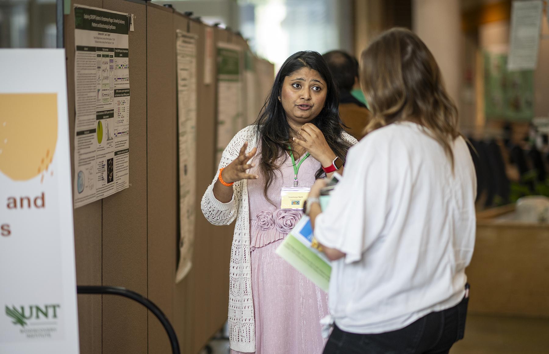 Photo of graduate student talking about research 