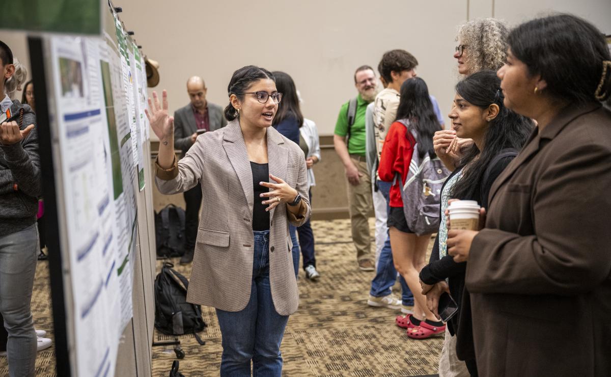 Photo of student presenting poster at University Research Day
