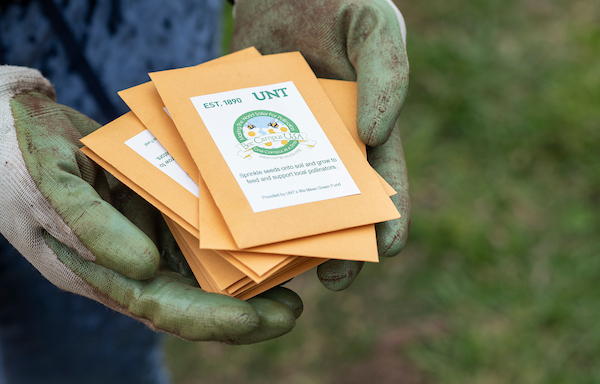 hands holding packets from community garden