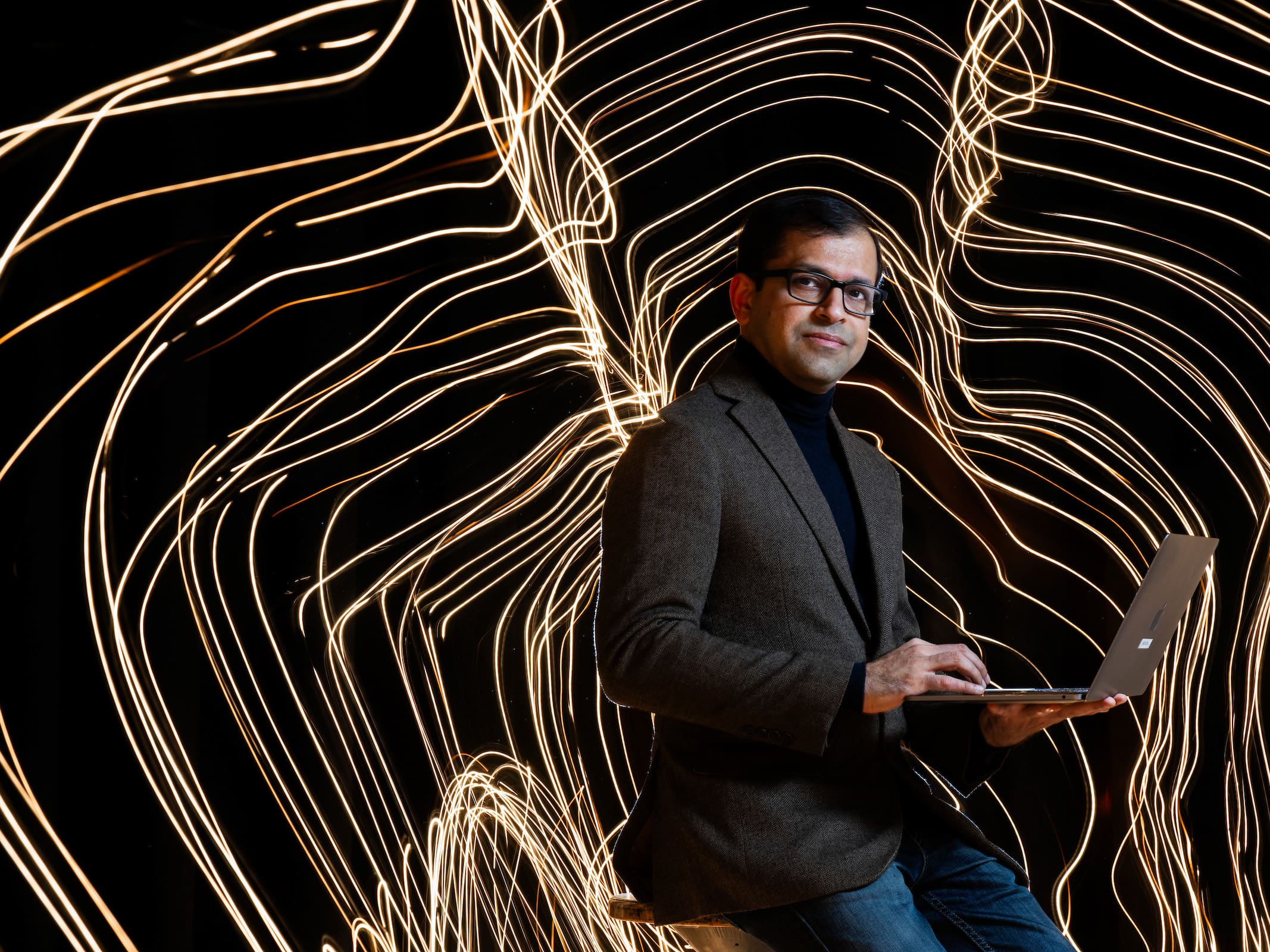 professor on computer with lights in background