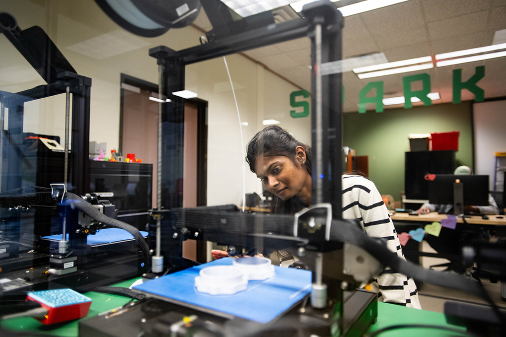 Photo of UNT Seemaparevez Shaik working on a 3D printer.