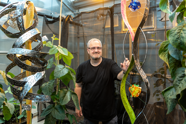 Phil Samson with sculpture in greenhouse