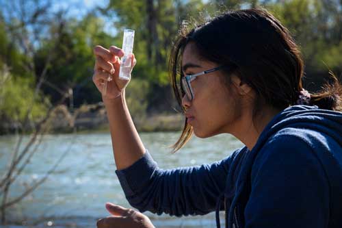 student researcher with test tube at LLELA